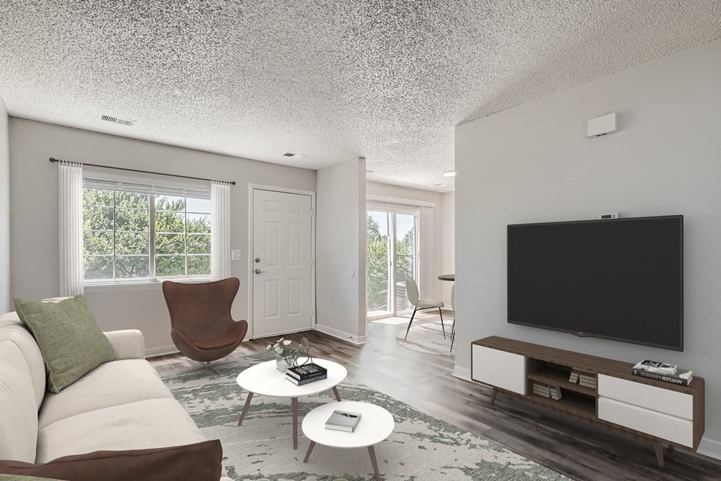 a living room with a white couch and coffee table and a flat screen tv on the wall