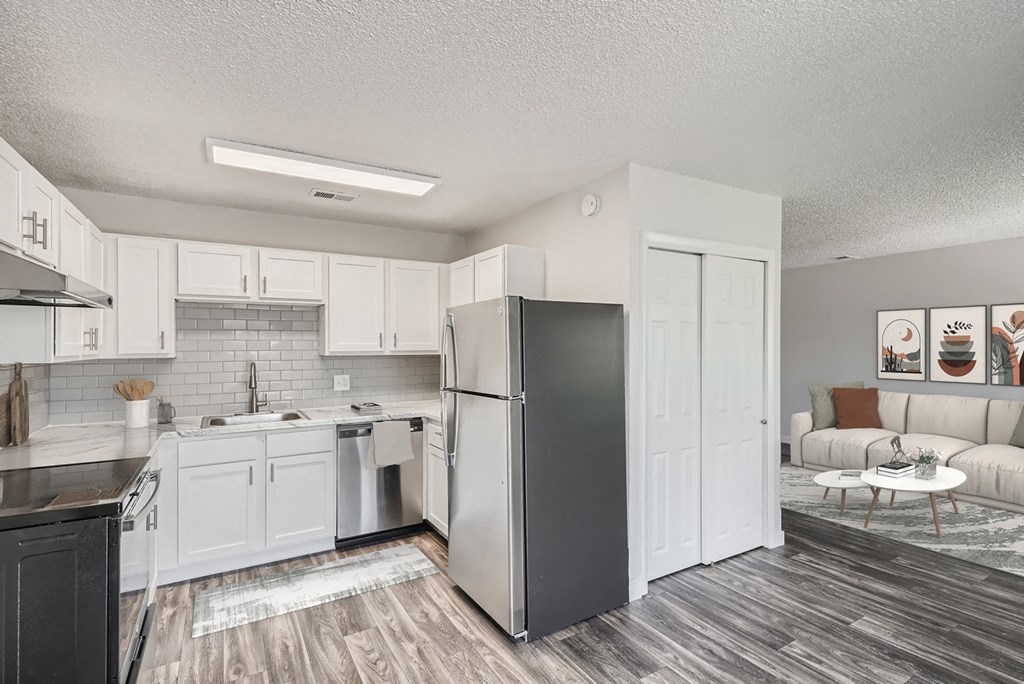 a kitchen with white cabinetry and a stainless steel refrigerator