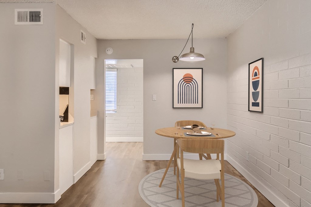 a dining area with a round table and two chairs