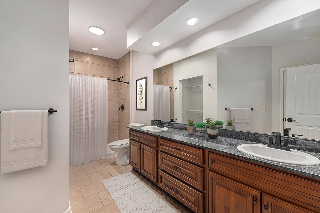 a bathroom with two sinks and a shower and a toilet