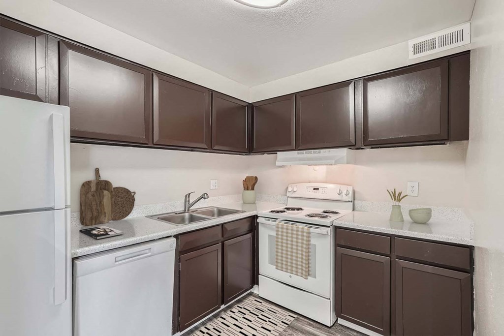 a kitchen with white appliances and brown cabinets