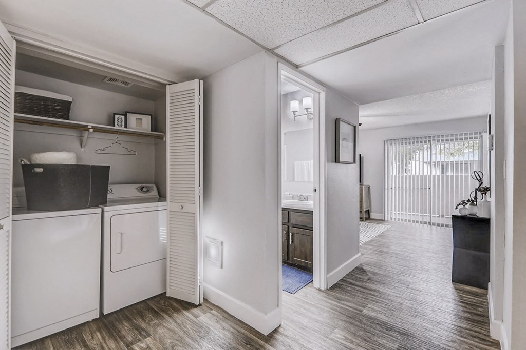 a kitchen with a washer and dryer and a door into a living room