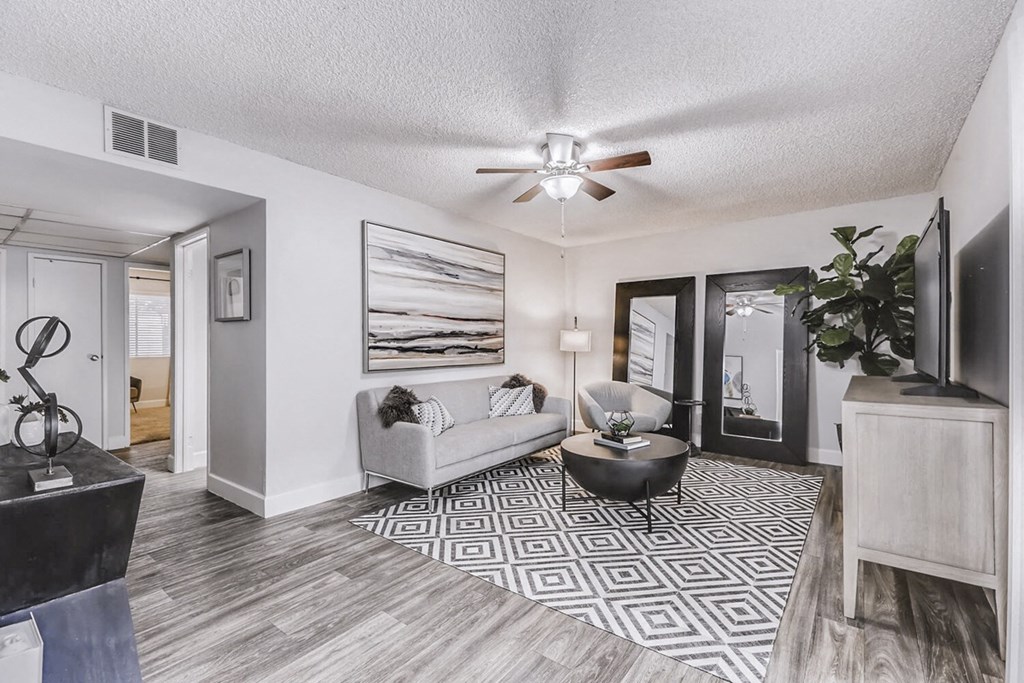 a living room with a couch and a ceiling fan