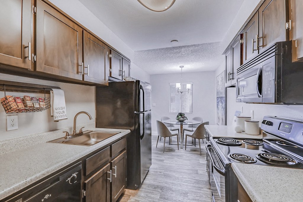 a kitchen with wooden cabinets and a stove and a sink
