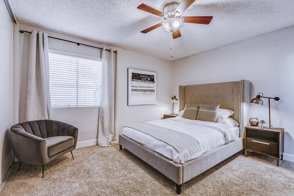 a bedroom with a bed and a ceiling fan