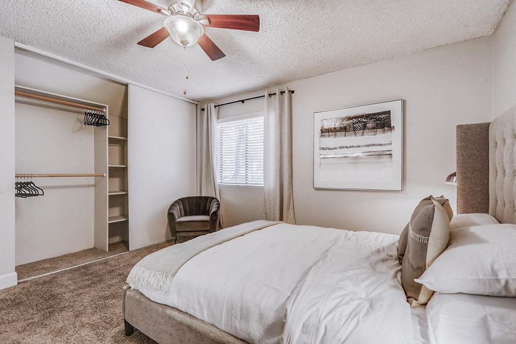 a bedroom with a large bed and a ceiling fan