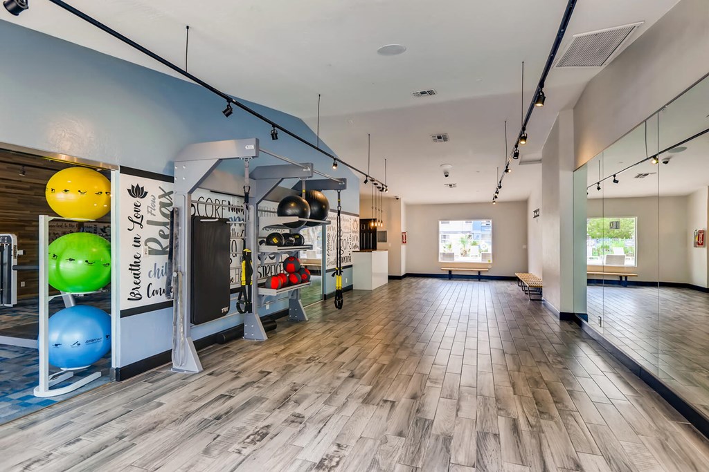 a workout room with a hard wood floor and a blue wall with spheres on it