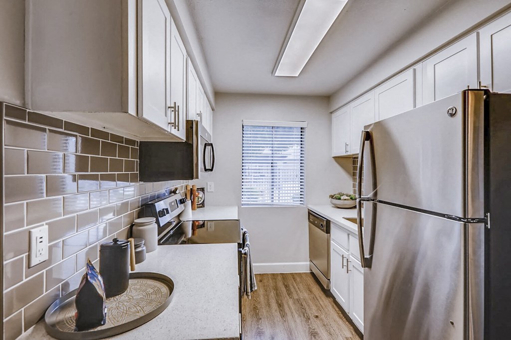 a kitchen with stainless steel appliances and white cabinets