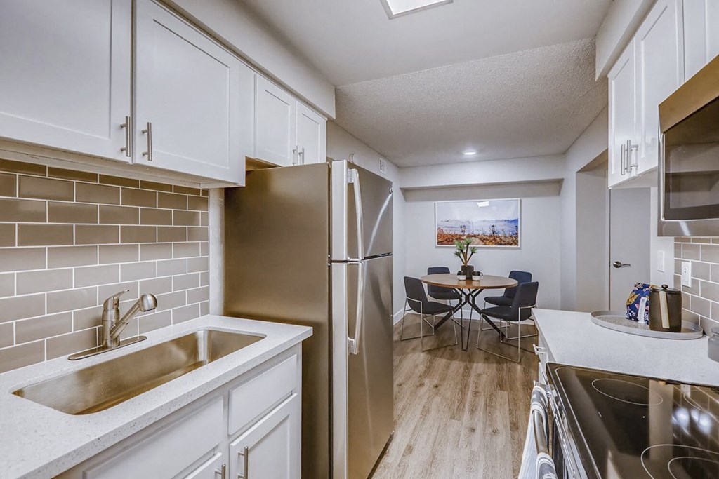 a kitchen with white cabinets and a stainless steel refrigerator