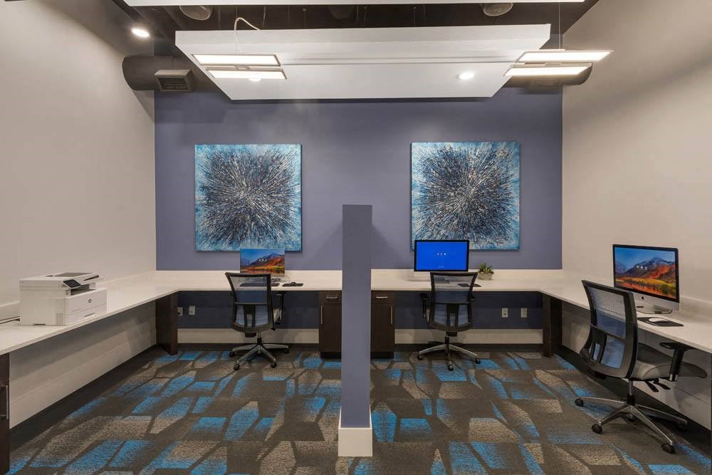 a conference room with desks and chairs and paintings on the wall