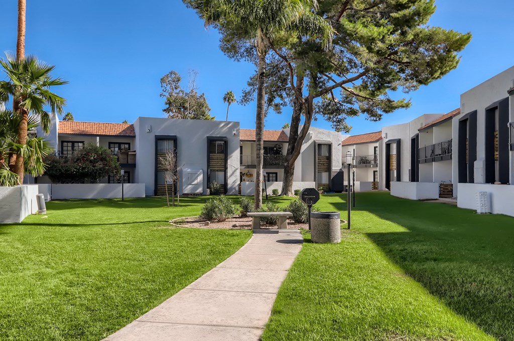 a group of apartments with a grassy yard and palm trees