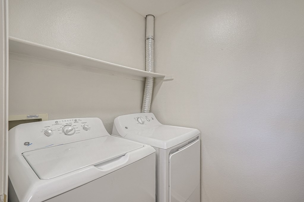 an empty laundry room with a washer and dryer