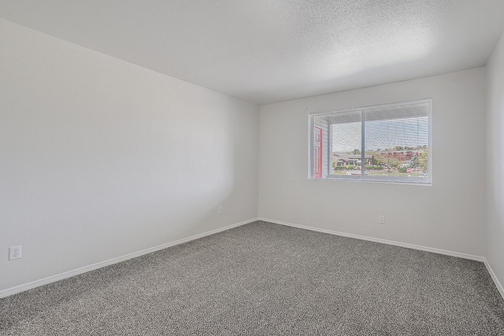 an empty room with carpet and a window