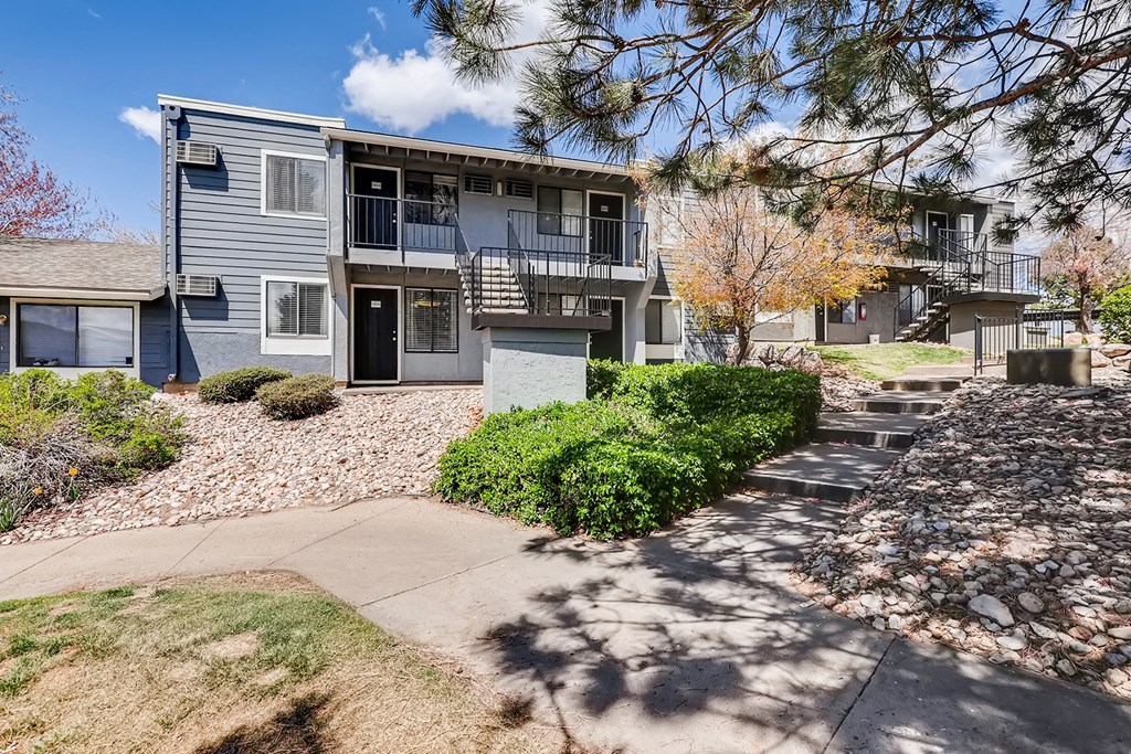 a blue house with a sidewalk in front of it