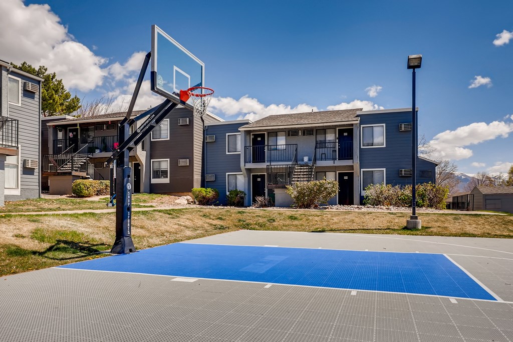 an outdoor basketball court with apartments in the background