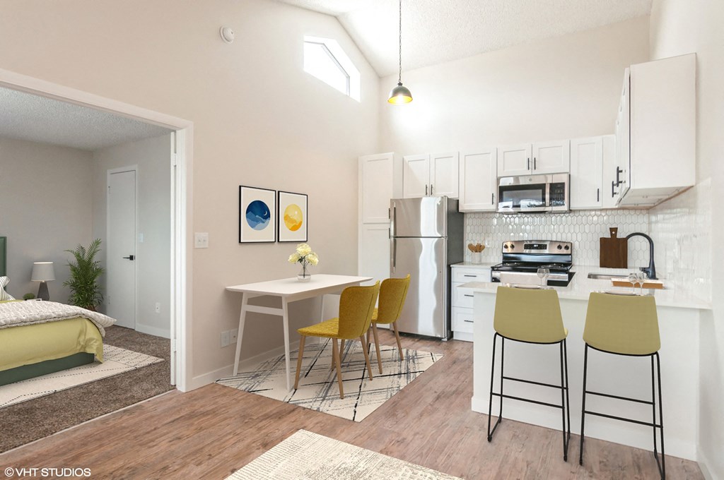 a kitchen and dining room with white cabinets and a table and chairs