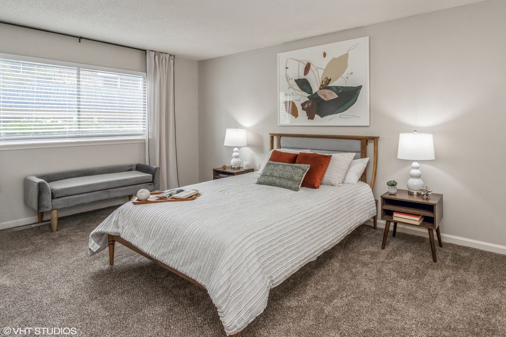 a bedroom with a bed and a couch and a window