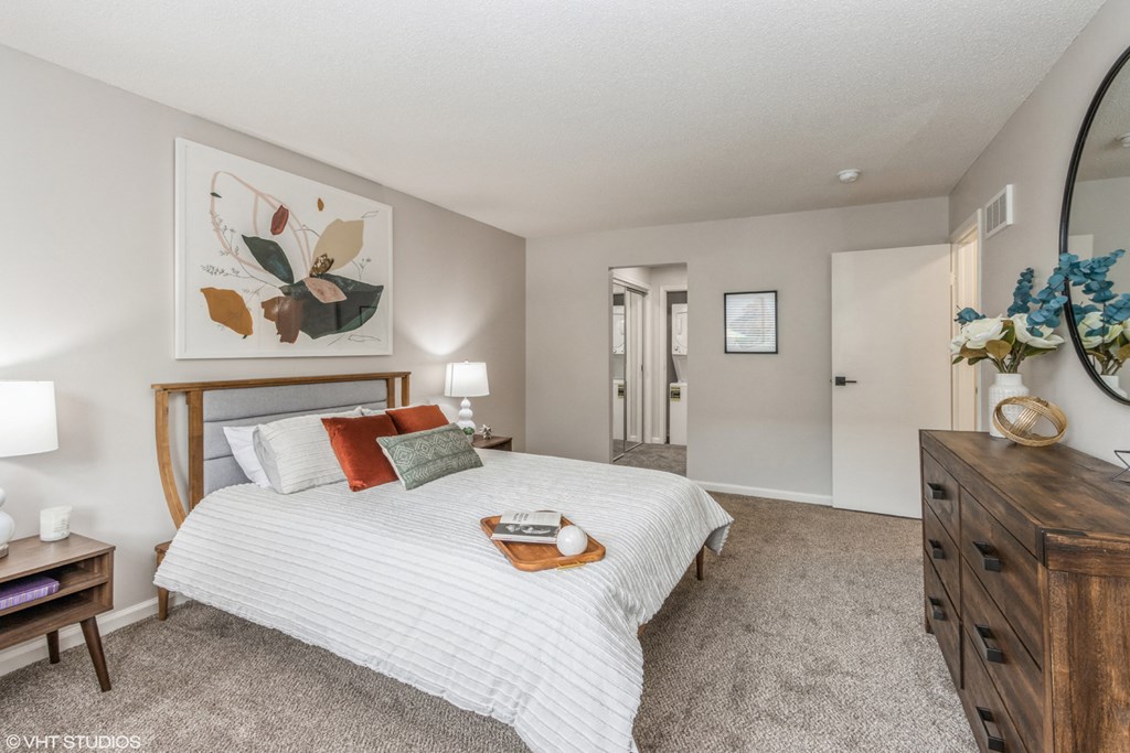 a bedroom with a bed and a dresser and a mirror