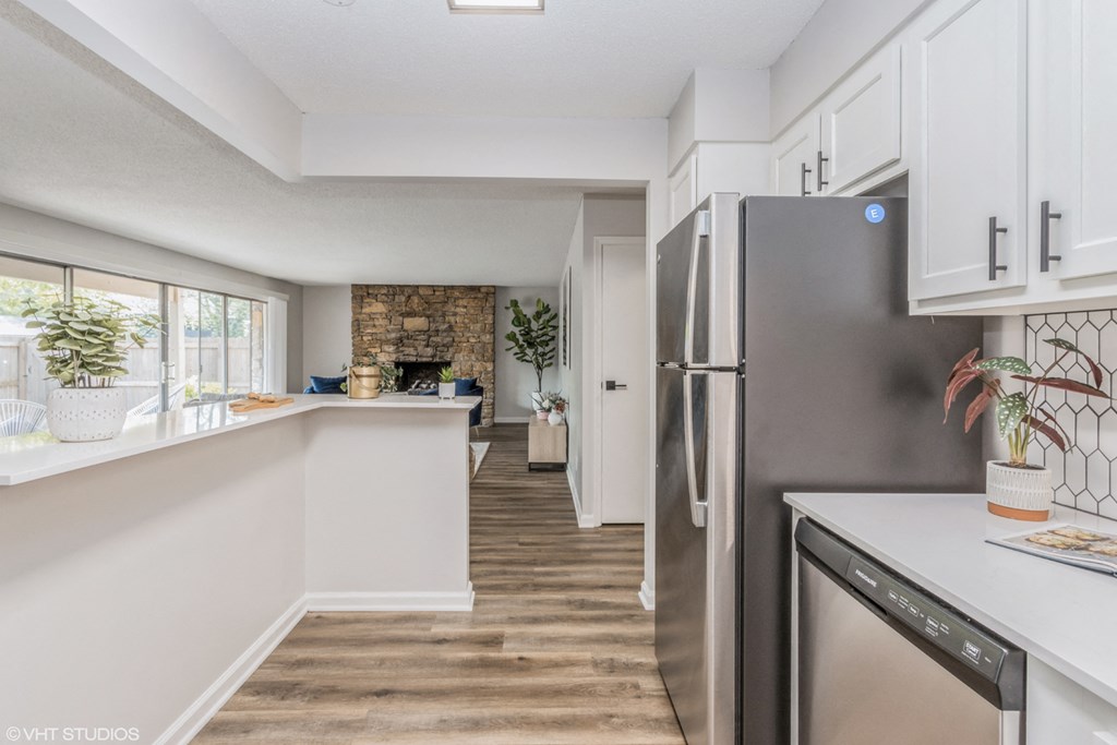 a kitchen with white cabinets and a stainless steel refrigerator