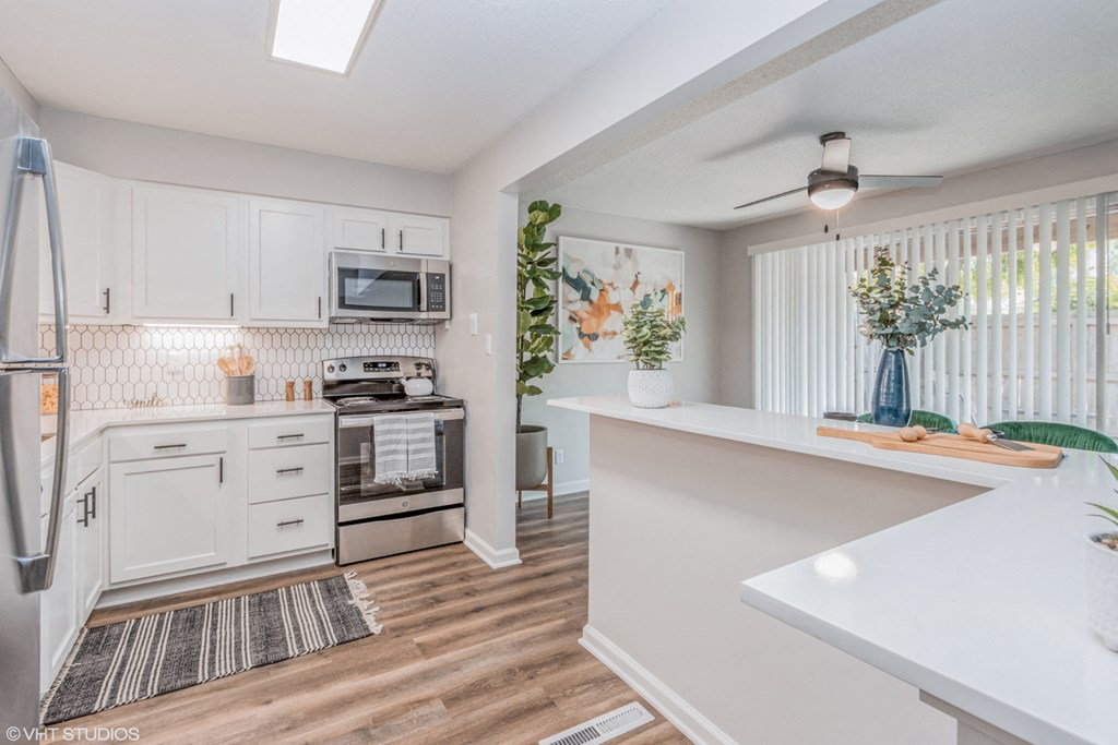 a renovated kitchen with white cabinets and a white counter top