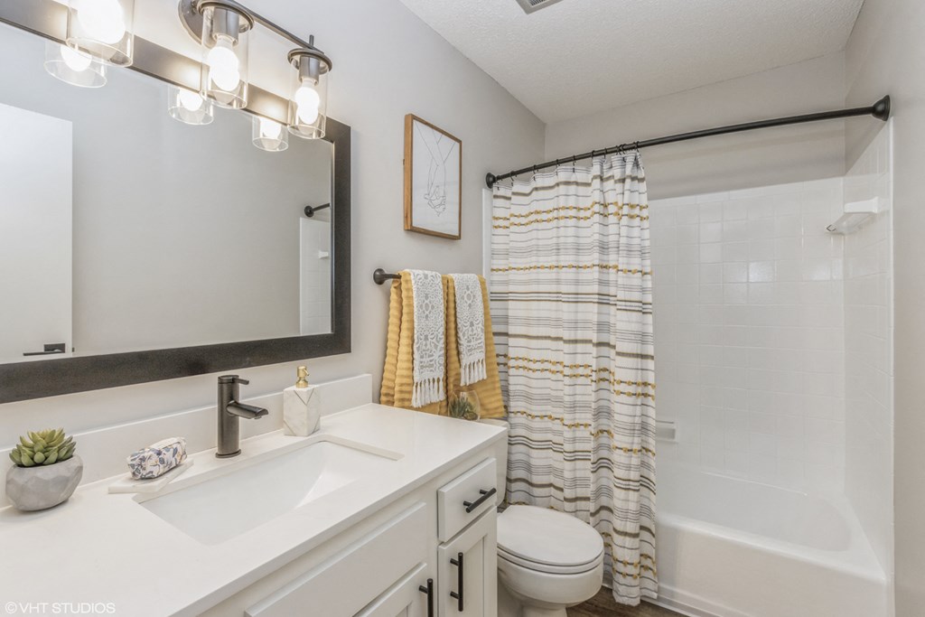 a white bathroom with a shower and a sink and a toilet