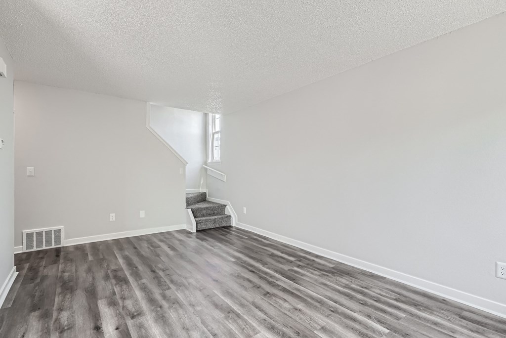 a living room with hardwood floors and grey walls