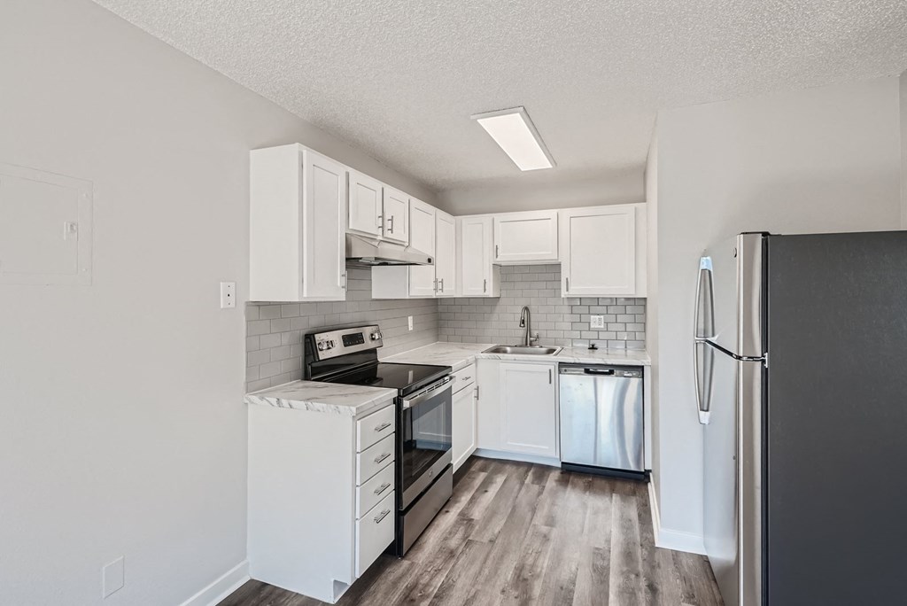 a kitchen with white cabinets and stainless steel appliances