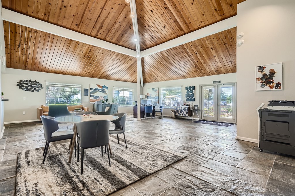 a large room with a wooden ceiling and a table and chairs