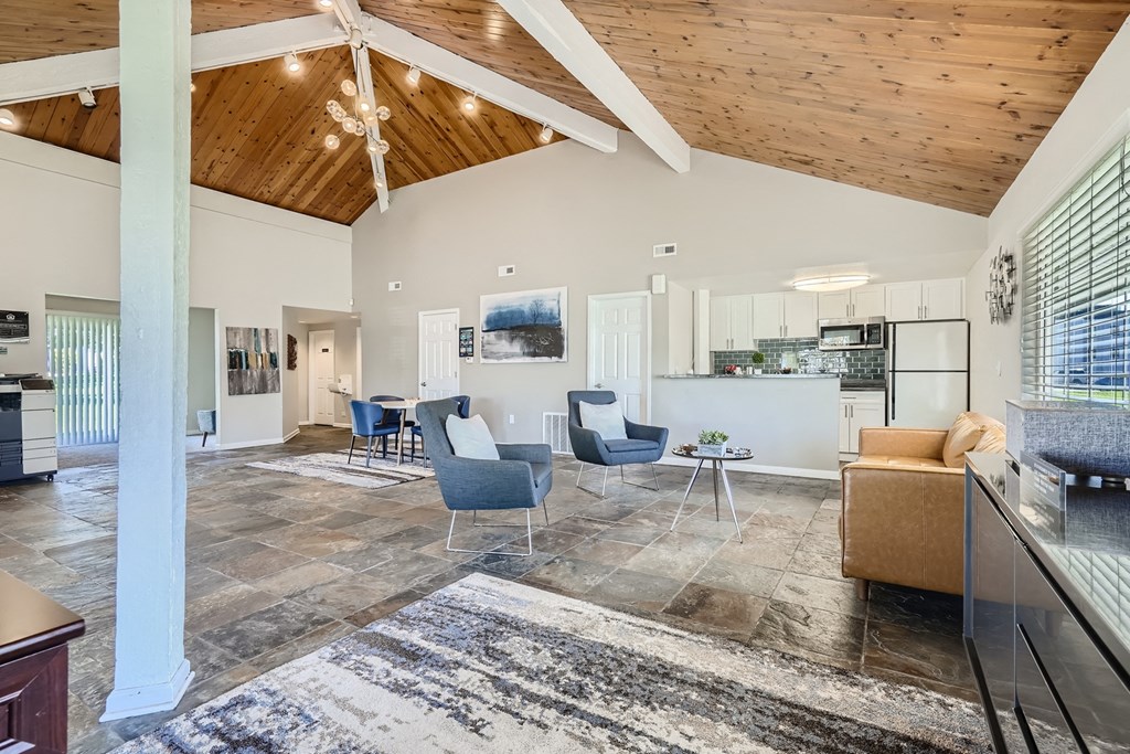 a spacious living room with a vaulted ceiling and tile flooring