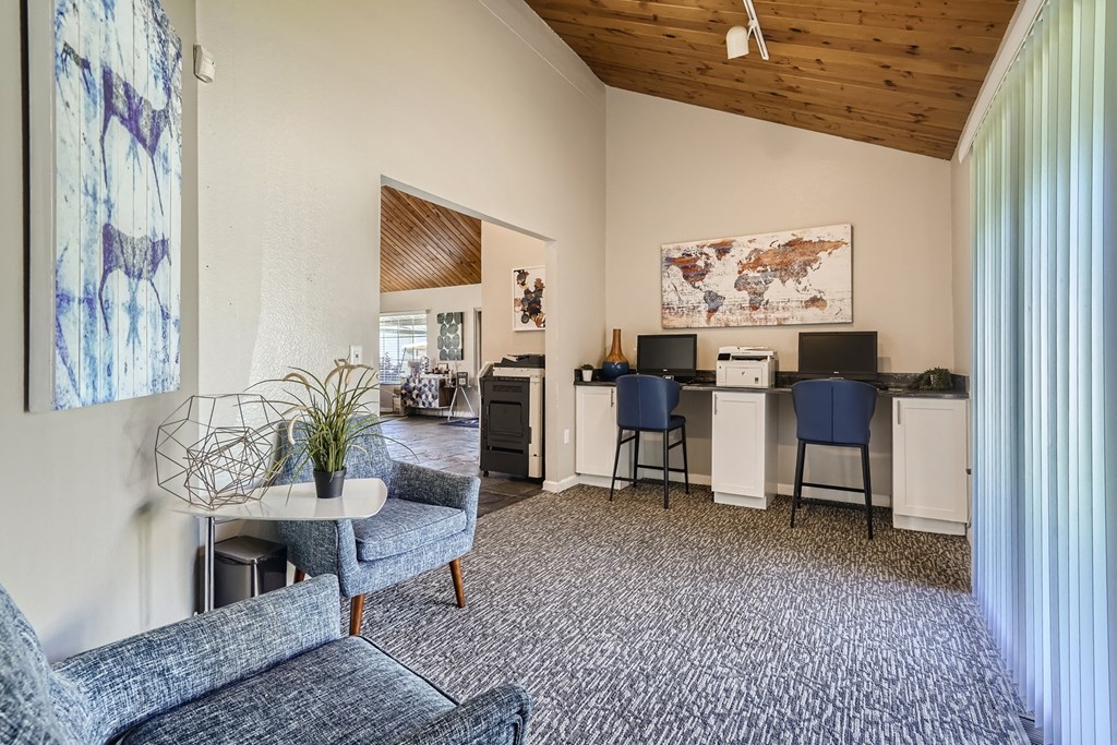 a living room with a couch a chair and a desk with a computer