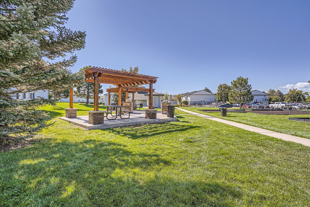 a pergola sits in the middle of a grassy area
