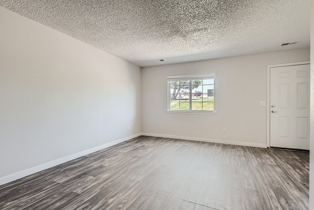 a bedroom with hardwood floors and white walls