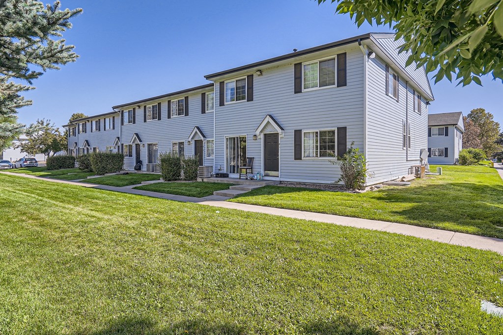 a large white house with green grass and trees in front of it