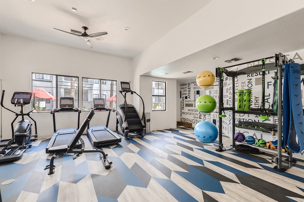 the gym with treadmills and weights at the apartments