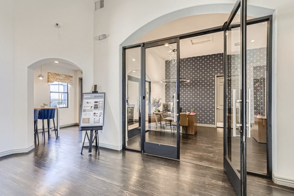 a living room with glass doors and a dining room in the background
