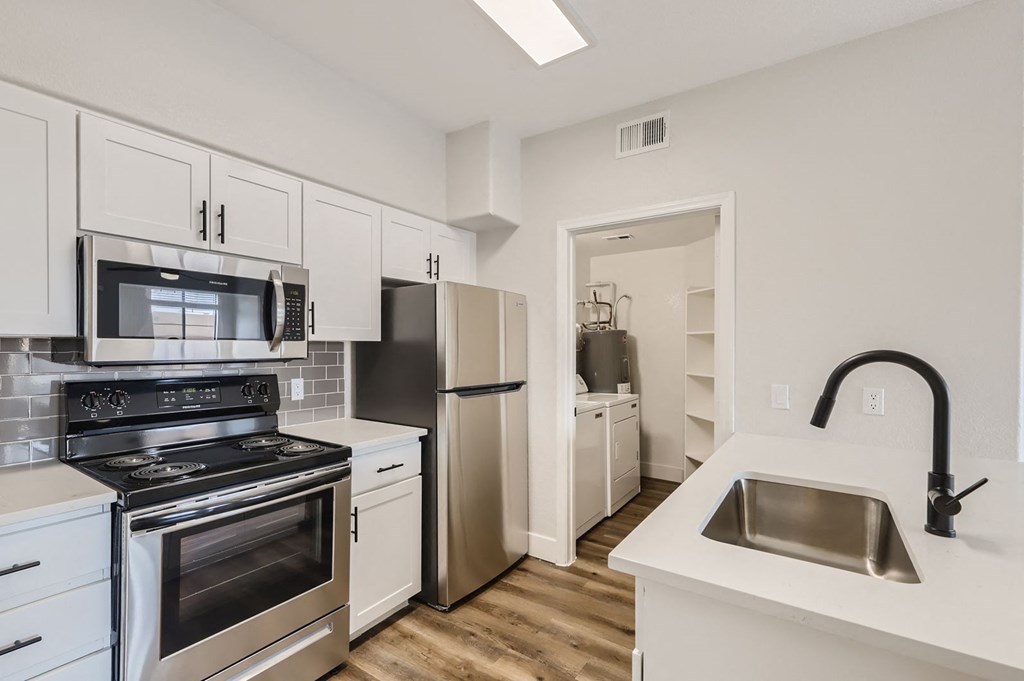 a kitchen with stainless steel appliances and white cabinets