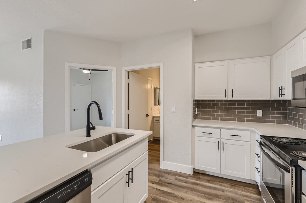 a kitchen with white cabinets and a sink