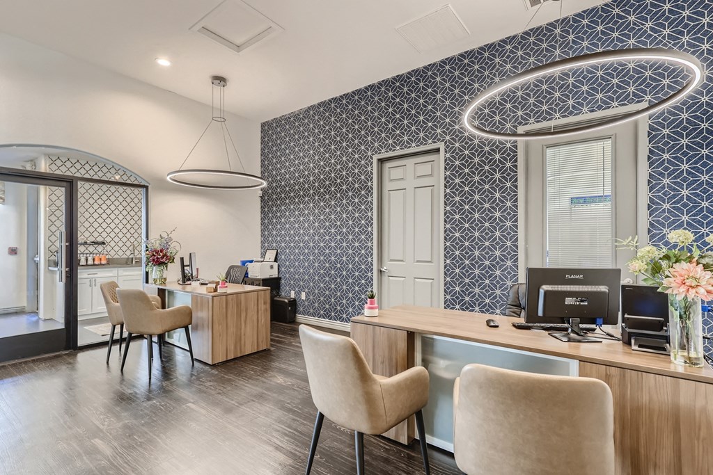 a reception area with chairs and a desk with a computer