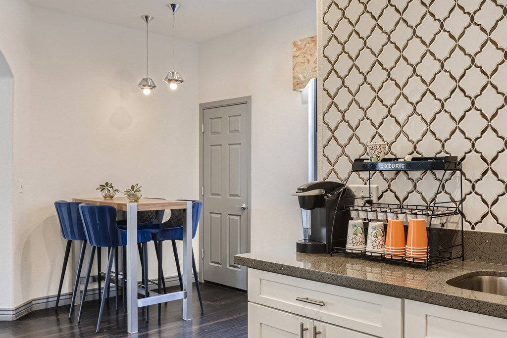 a kitchen with a counter top and a bar with blue stools