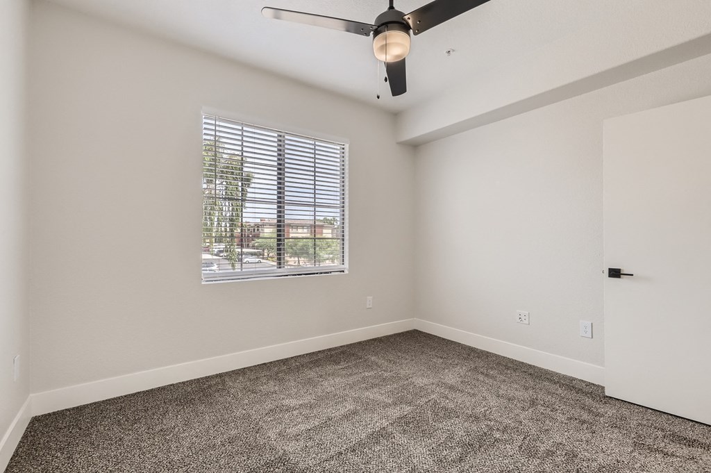 an empty living room with carpet and a window