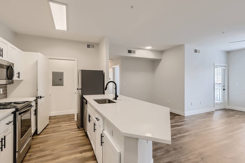 a kitchen with a white counter top and a sink