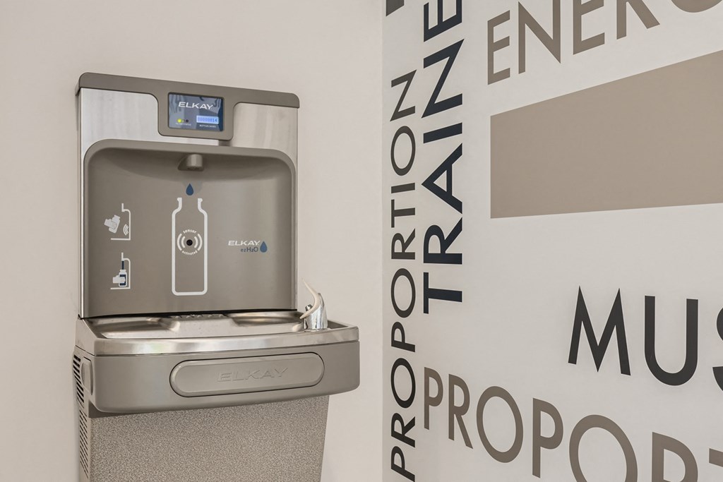 a water dispenser on a wall next to a water fountain