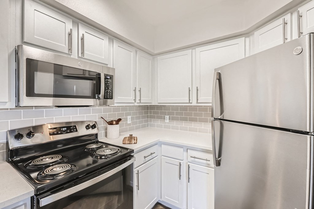 a kitchen with white cabinets and stainless steel appliances