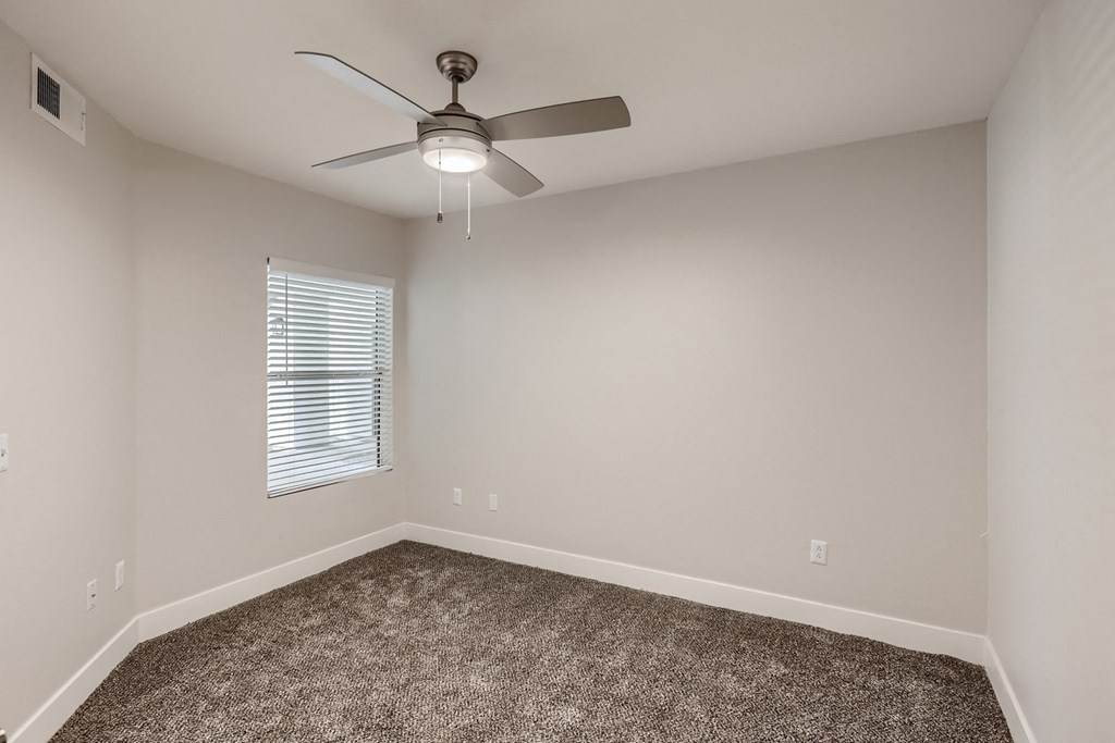 a bedroom with a ceiling fan and a window
