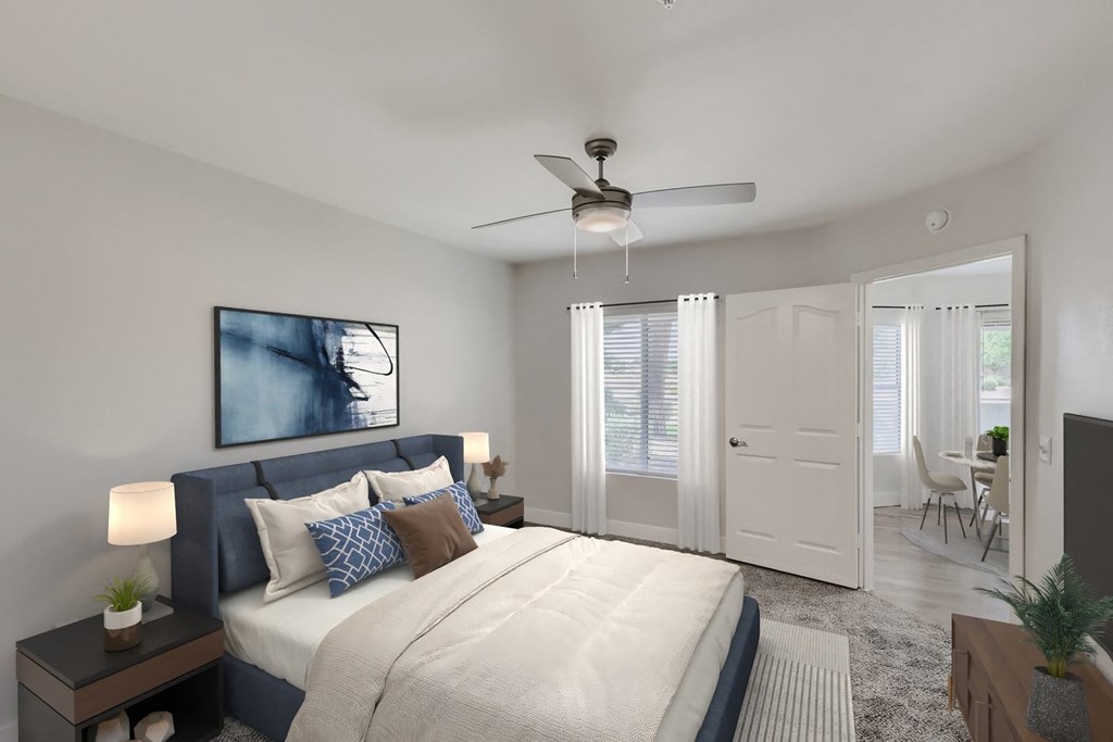 a bedroom with a large bed and a ceiling fan