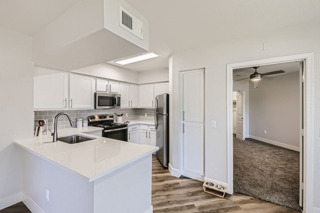 a kitchen with white cabinets and stainless steel appliances