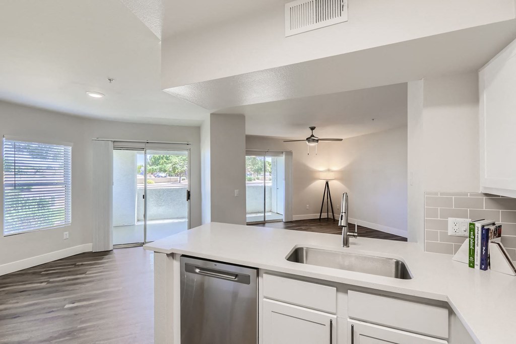 a kitchen with white cabinets and a stainless steel dishwasher