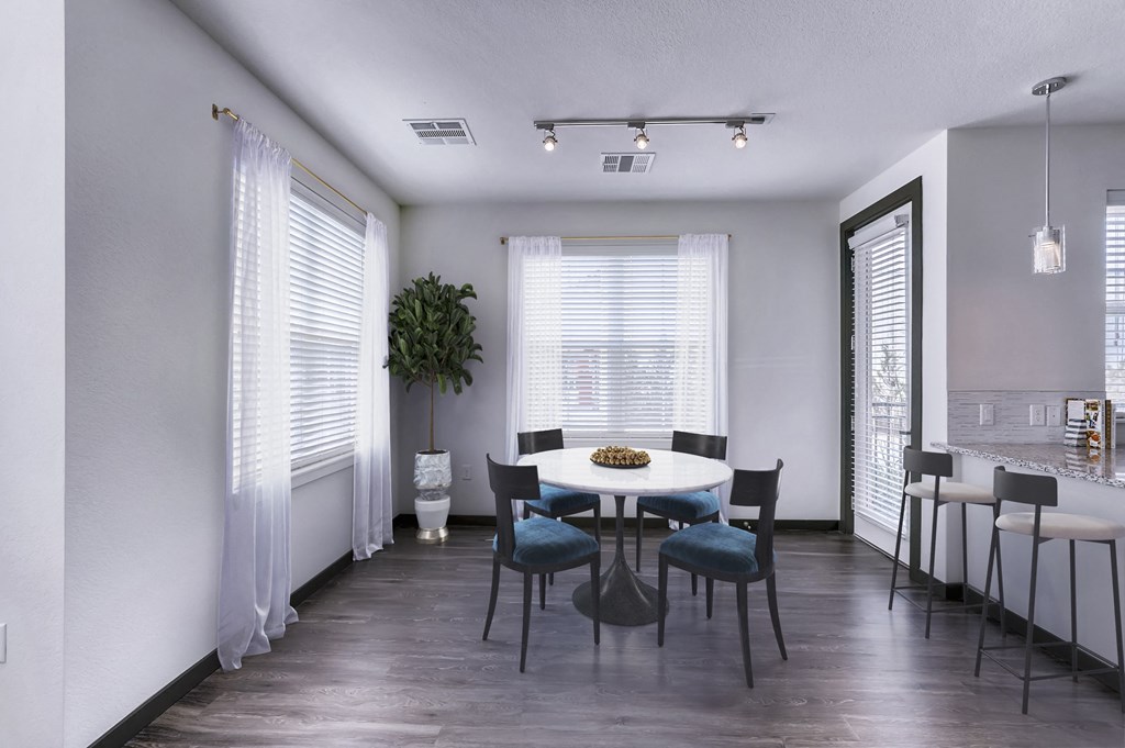 a dining room with white walls and a white table and chairs