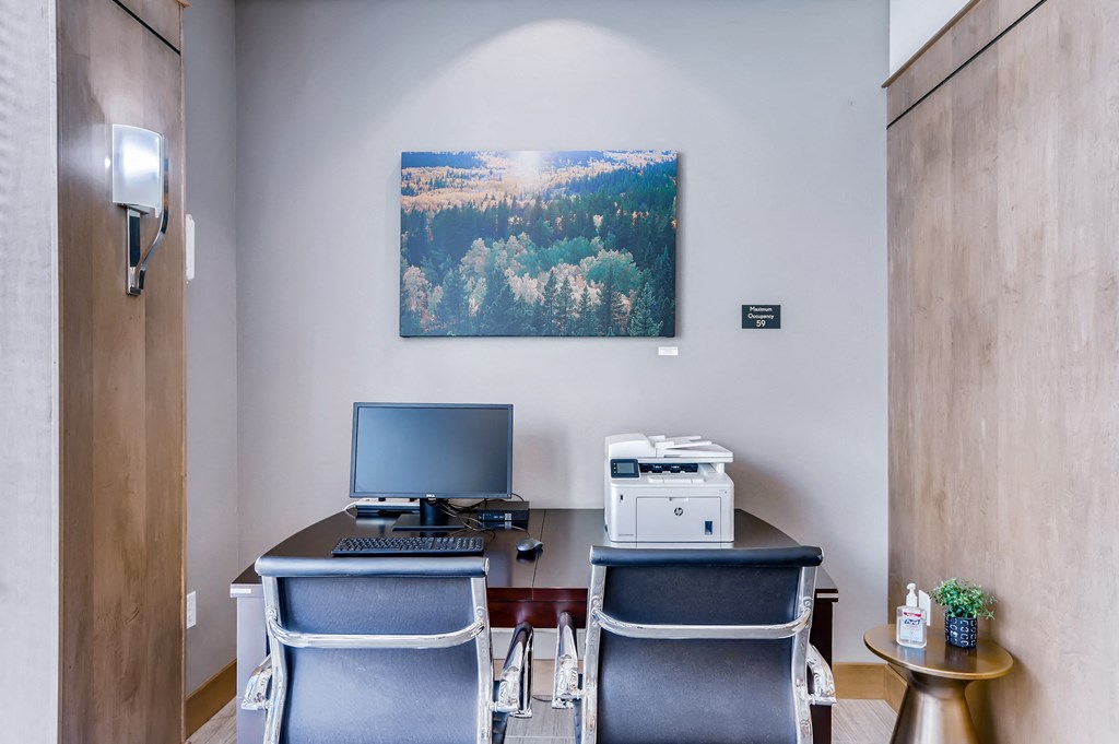 a desk with a computer and a printer in an office