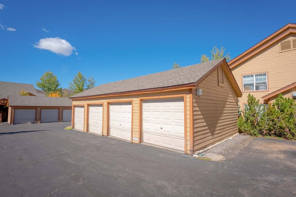 a garage with three doors in front of a house